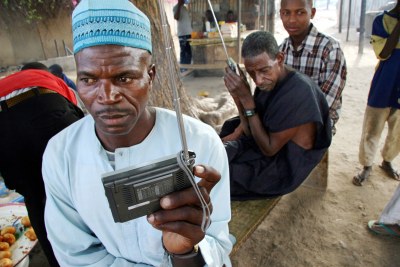 Nigerians listen for the latest election news on their radios in Kano, northern Nigeria, 19 April 2007. Vice-President Atiku Abubakar of the Action Congress Party, former military ruler Muhammadu Buhari of the All Nigeria People's Party, and Umaru Musa Yar'Adua of the ruling People's Democratic Party are the three favorites to win the Nigerian presidential elections on 21 April 2007.
