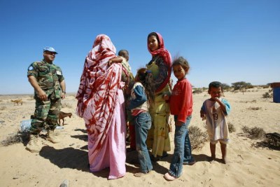 A member of the UN Mission for the Referendum in Western Sahara (MINURSO)'s Military Liaison Office chats with a group of local Western Saharans (file photo).