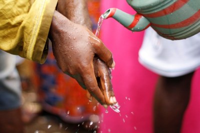 A man washes his hands during a cholera prevention session.
