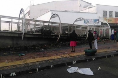 People take a look at burnt remains of goods.