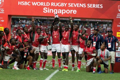 Kenya sevens rugby team players celebrate with the Main Cup trophy after beating Fiji 30-7 in the final of the Singapore Sevens tournament.