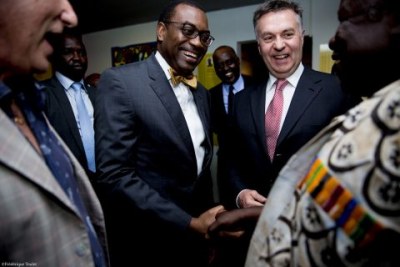 President of the Africn Development Bank (AfDB) Akinwumi Adesina (center) and co-president of African Artists for Development (AAD), Matthias Leridon, greet the acclaimed Ghanaian coffin artist Paa Joe at the opening of the “Lumières d’Afriques” (