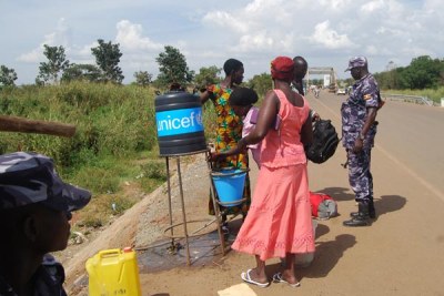 Women from South Sudan sanitise hands at the Ugandan border point of Elegu in Amuru District before entering the country as one of the measures to control the spread of cholera.