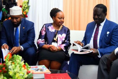 Opposition leader Raila Odinga (right) leafs through a book in the company of Kirinyaga Governor Anne Waiguru and Mombasa Governor Hassan Joho during the devolution conference (file photo).