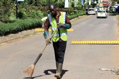A groundsman sweeps the entrance to DusitD2 Hotel.