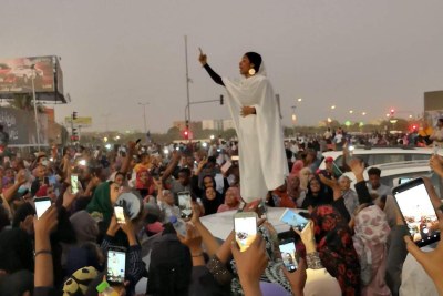 In what has become an iconic image of the Sudan protests, 22-year-old architectural engineering student Alaa Salah (@oalaa_salah) chants poetry from the top of a car, wearing traditional dress (file photo)..