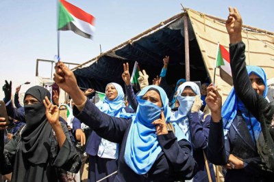 Sudanese women wave flags during outside army headquarters in Khartoum (file photo).