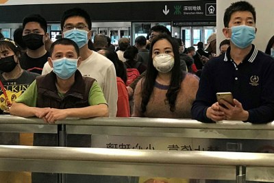 People wear face masks as they wait at China's Shenzhen Bao'an International Airport arrivals.