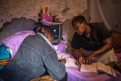 Florian helping her daughter Sheila Achieng do her revision at home in Kibera as schools are closed due to the Covid-19 pandemic (file photo).