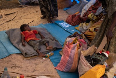 A young Ethiopian refugee sleeps on a mattress at a transit site in Hamdayet, Sudan.