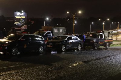 Police vehicles on standby at Thika Superhighway's Exit 7 as police officers await to block curfew violators in Nairobi on April 19, 2021.