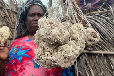Nasir Hassan Haji holds up her harvested sponges in a bag from her home in Jambiani in Zanzibar, Tanzania. June 21, 2021.