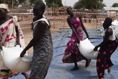 Displaced people in Bor, South Sudan, collect food aid. The conflict in Ukraine and resulting sanctions on Russia are driving up global oil and food prices, which could lead to increased hunger in Africa, analysts say.
