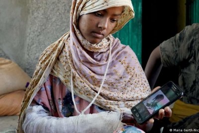 A young girl with her arm in a cast after being shot.