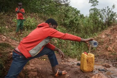 A 16-year-old boy collects spring water near the Lega Dembi gold mine in the Oromia region of Ethiopia.