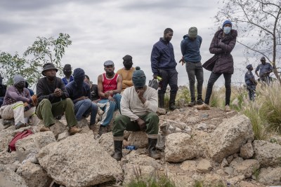 Men involved in a rescue operation wait near the mineshaft.