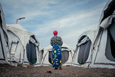 A female patient standing between tents set up for the treatment of sexual violence survivors and women's health issues at Mugunga 3 Health Centre in Goma.