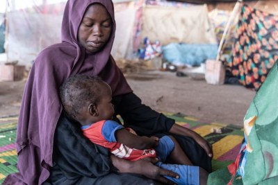 A mother looks after her child at a camp for displaced people in Gedaref, Sudan, after fleeing her home.