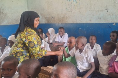 Rehema Matola, the health teacher at Vikuruti Primary School, giving students medication as part of the Mass drug administration.