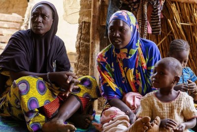 Women and children sit in a shelter in March 2024 at a site in Soucoura, Mali, hosting refugees from Burkina Faso who fled violence.