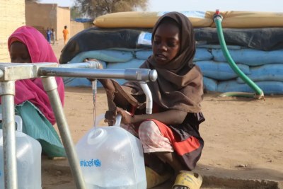 A girl collects water from a water point installed by UNICEF in a camp for displaced people in Tawila.