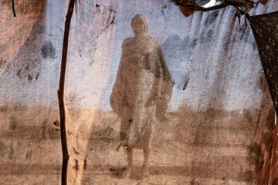 A woman stands outside her tent four months after fleeing the city of from El Fasher in Darfur following an attack.