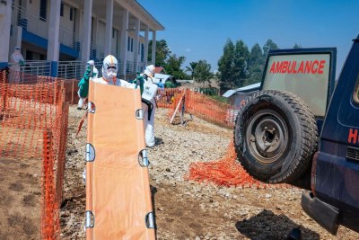 A health worker carries a stretcher into an Ebola treatment centre in the DR Congo.