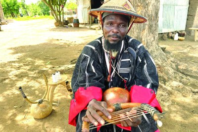 Dagnir Guekoumaté Dabiré tenant le koridjôme, la guitare traditionnelle Birifor.